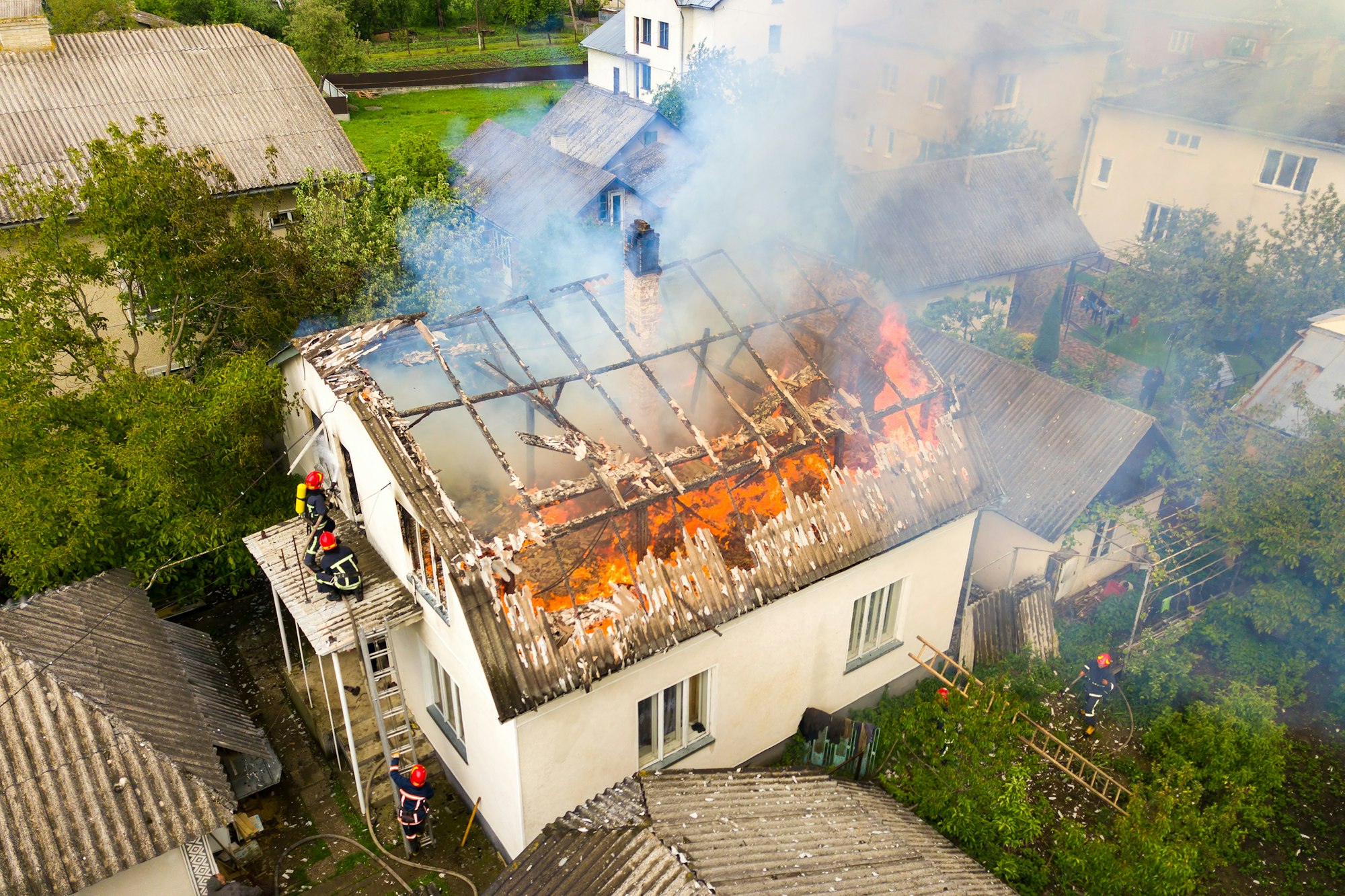 Vue aérienne d'une maison en feu avec flammes et fumée épaisse